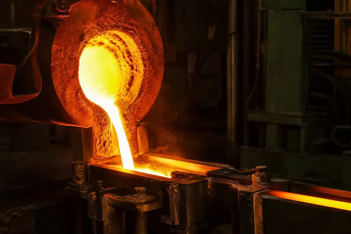 Liquid brass being poured from a medium frequency induction furnace into a continuous billet casting mold in Jamnagar